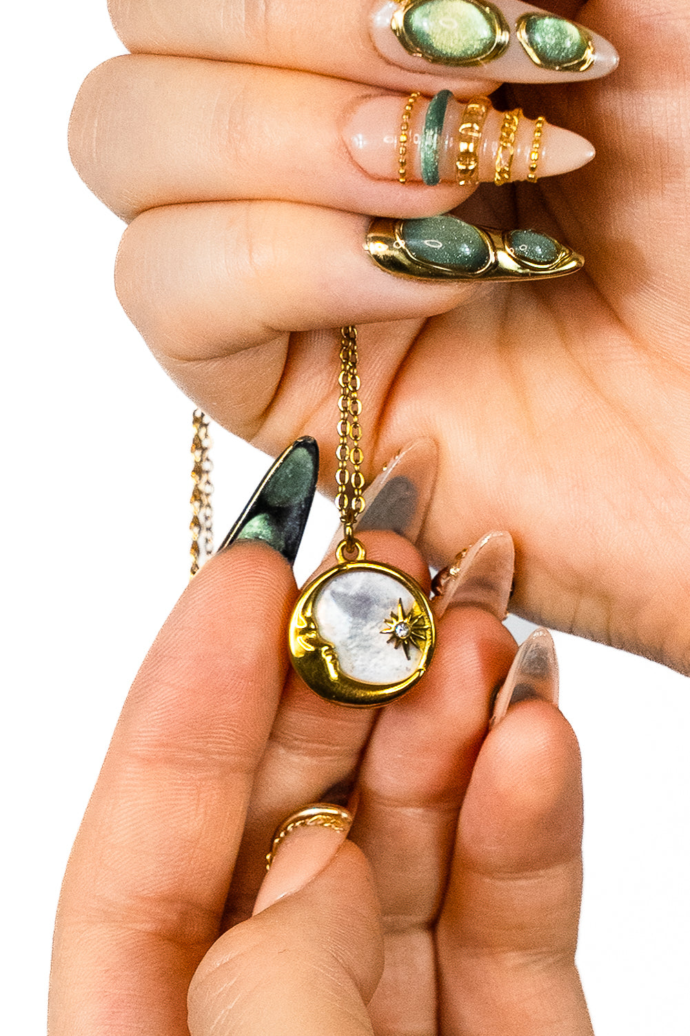 Pendentif collier spirituel Lune or nacre tenu dans des mains de femmes avec ongles 