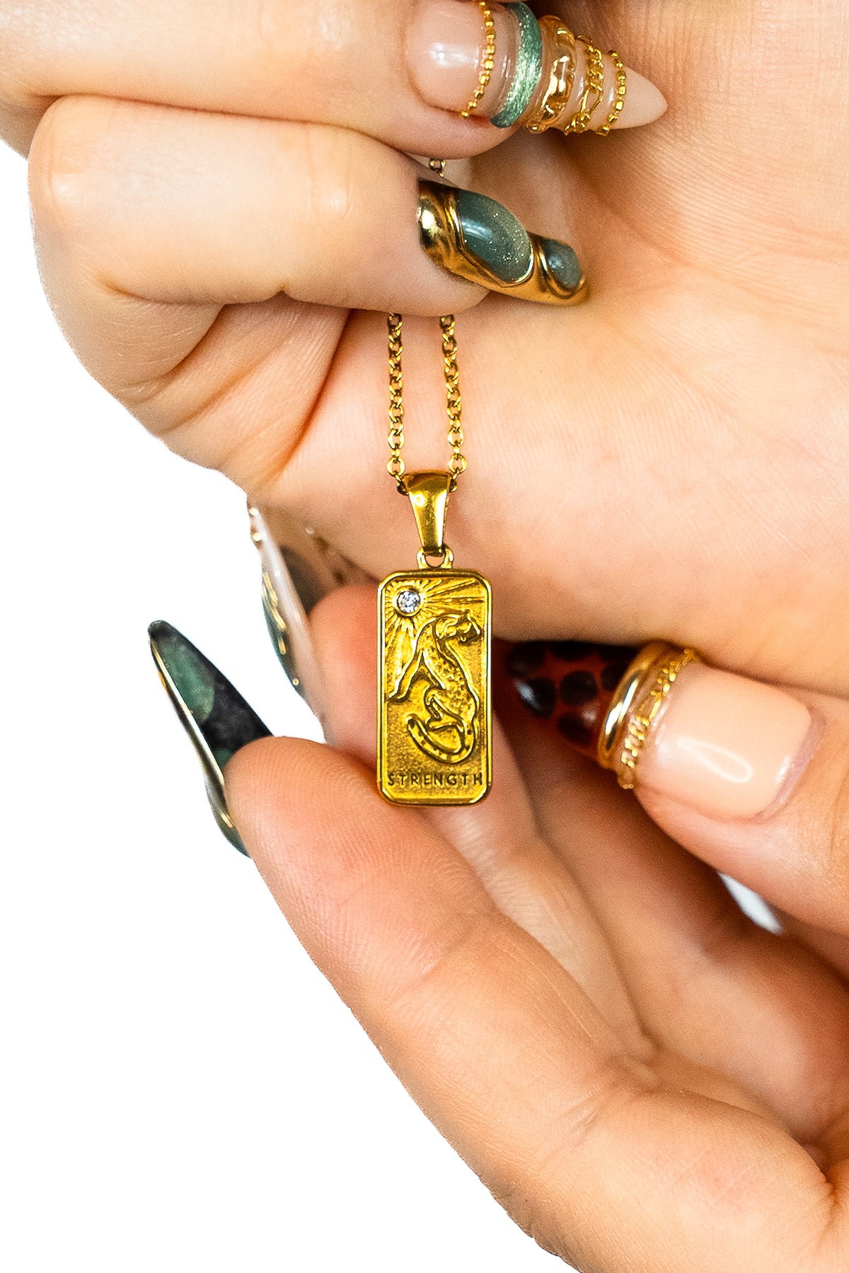 Pendentif collier spirituel Jaguar force forme carte de tarot avec pierre zircon en or tenu dans des mains de femme