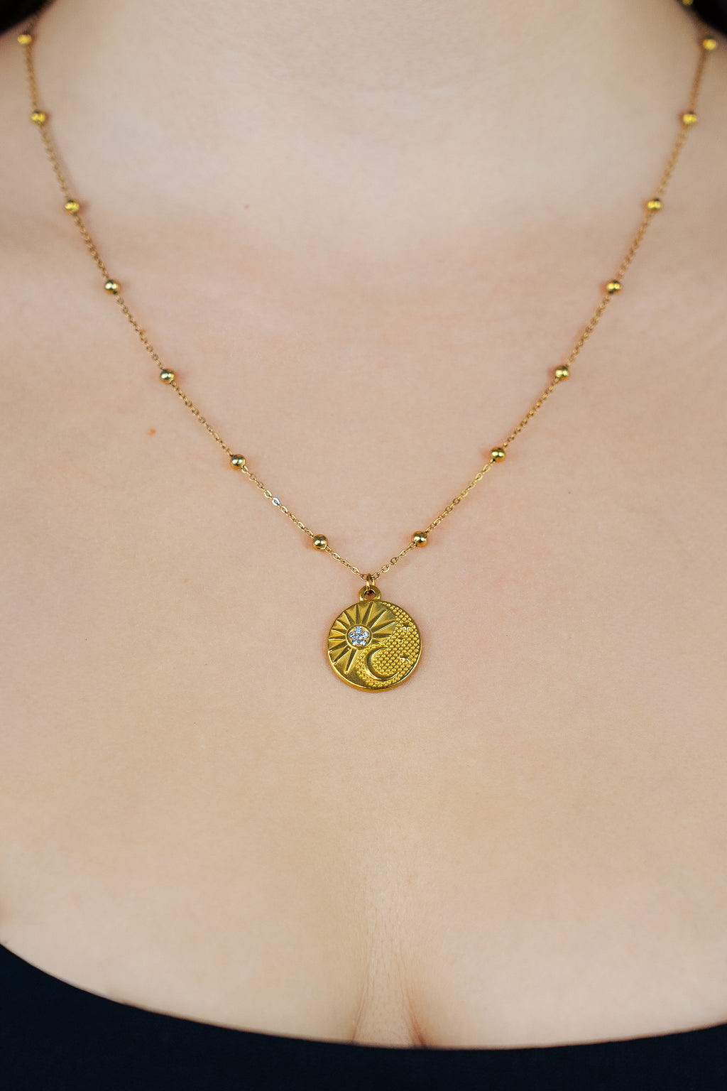 Collier pendentif spirituel rond soleil et lune avec strass en zircon et chaîne avec boules sur buste de femme