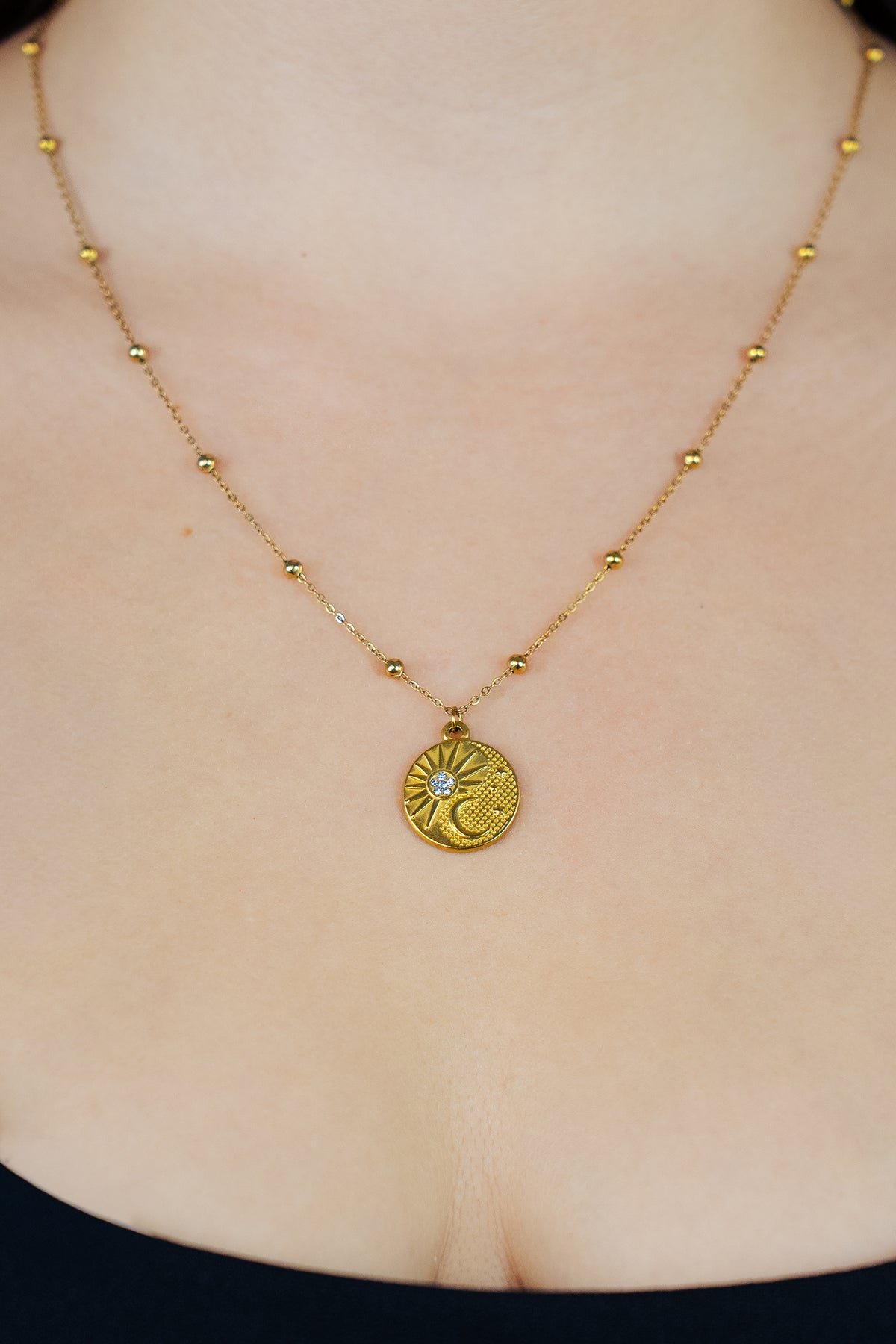 Collier pendentif spirituel rond soleil et lune avec strass en zircon et chaîne avec boules sur buste de femme